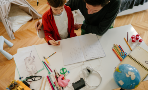 Father helping a child with schoolwork at a desk.